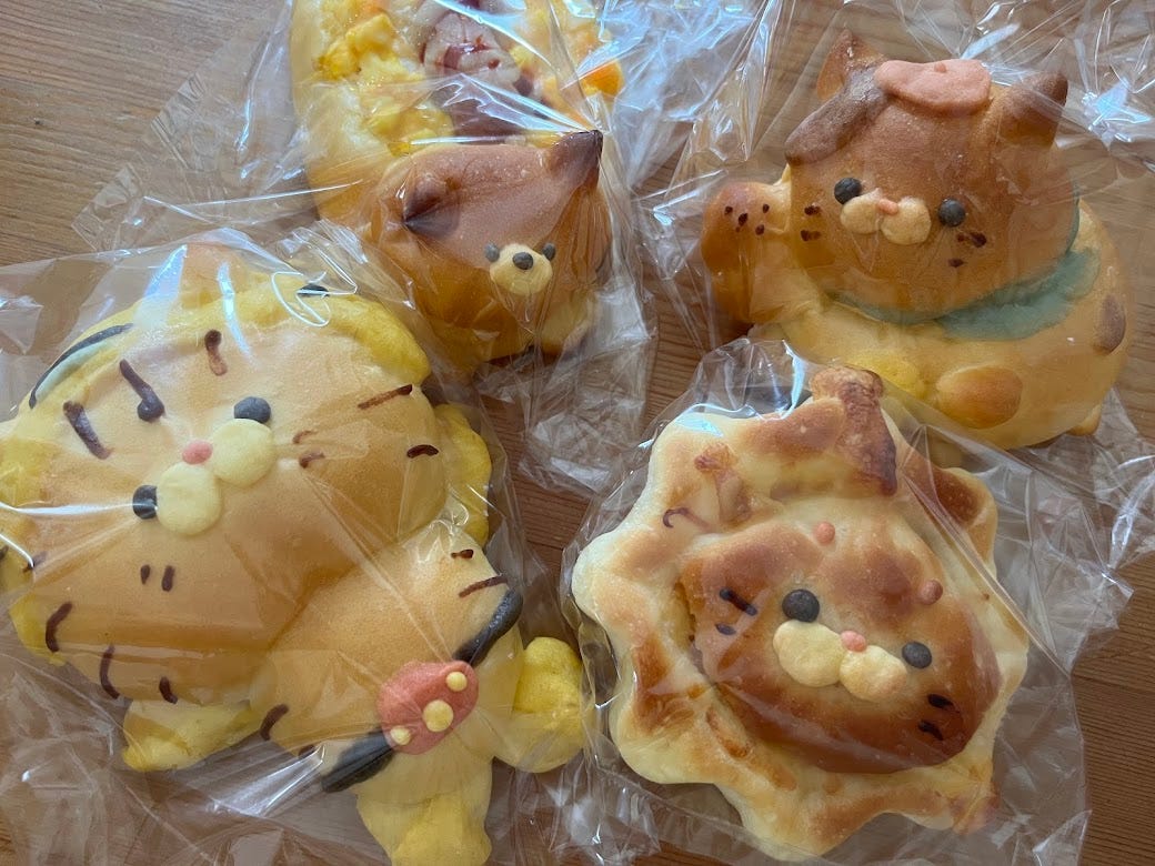 A selection of cute breads shaped like cats, dogs, maneki-neko (lucky cats), and lions.