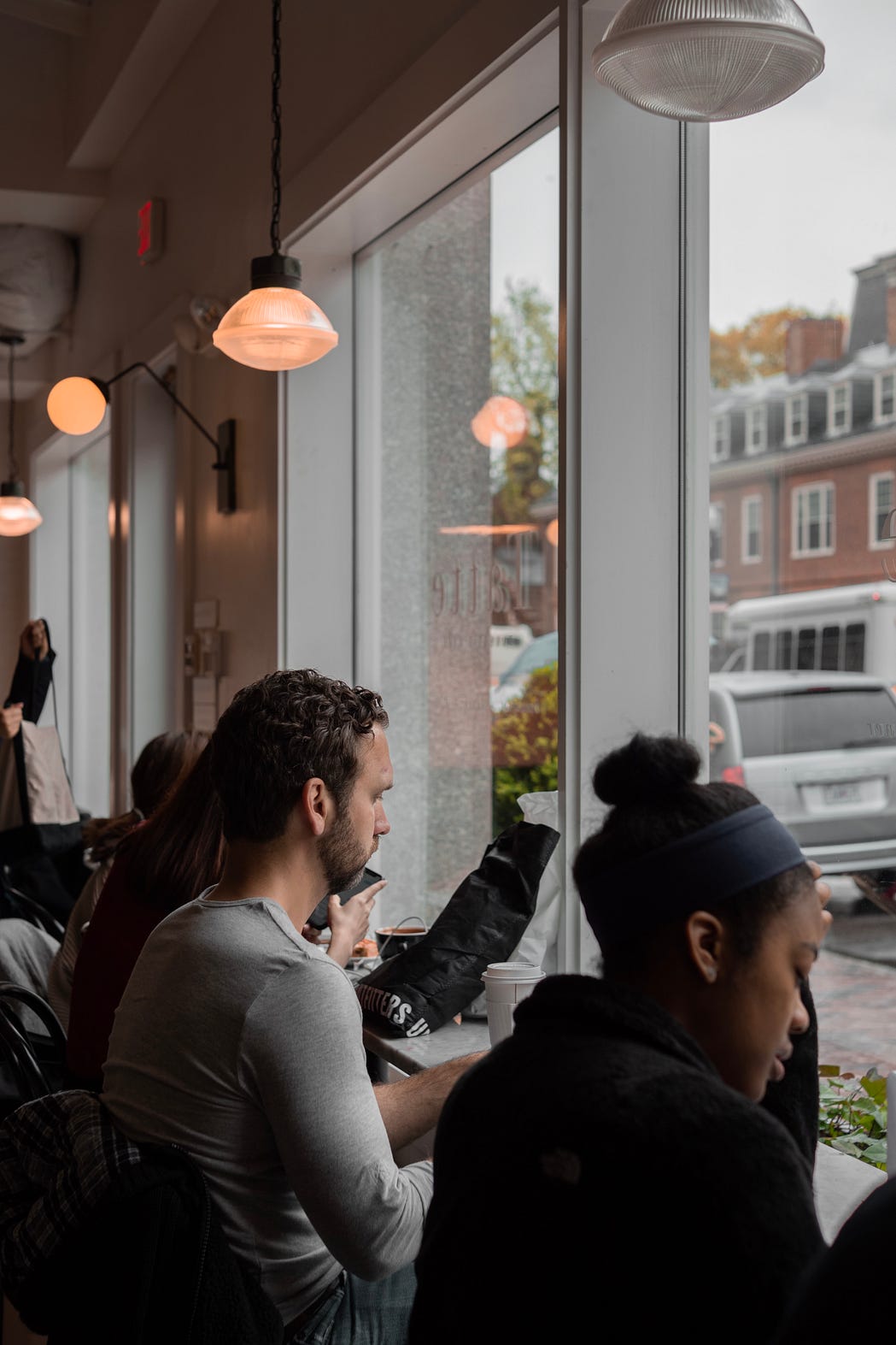 Picture of two strangers sitting next to one another at  a counter.