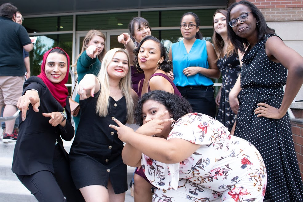 People making silly poses on steps.