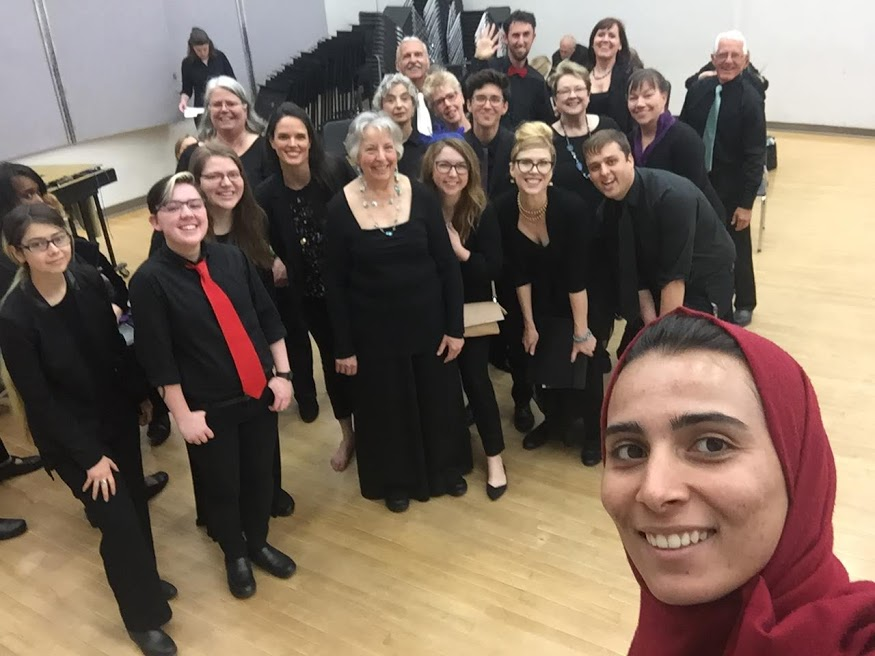 People taking a selfie wearing long black dresses.