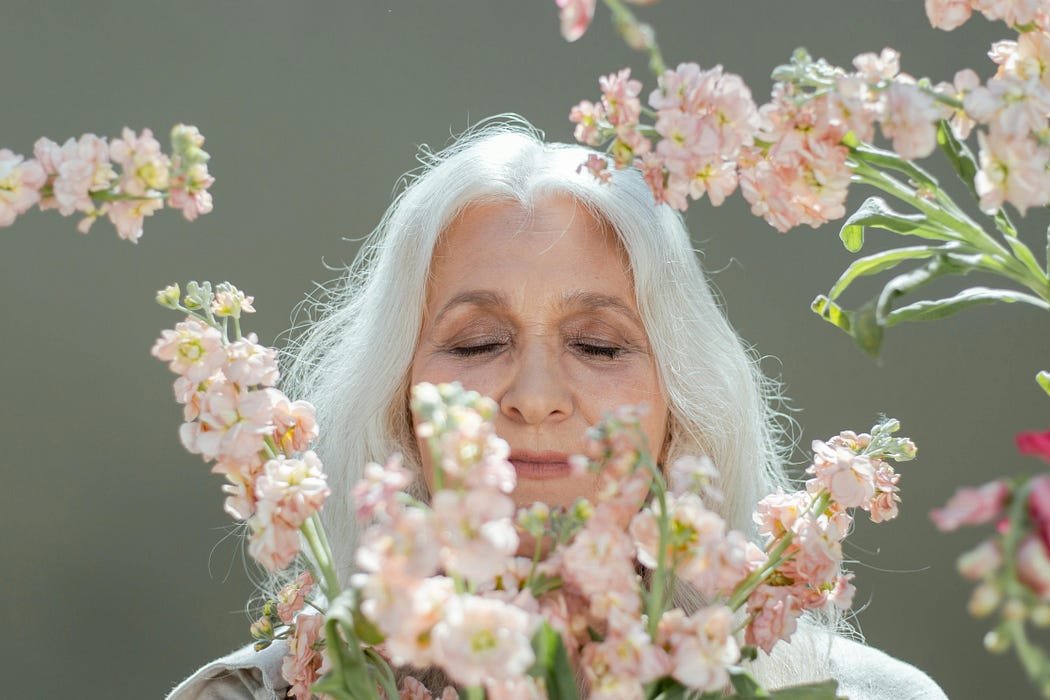 Older woman smelling the flowers