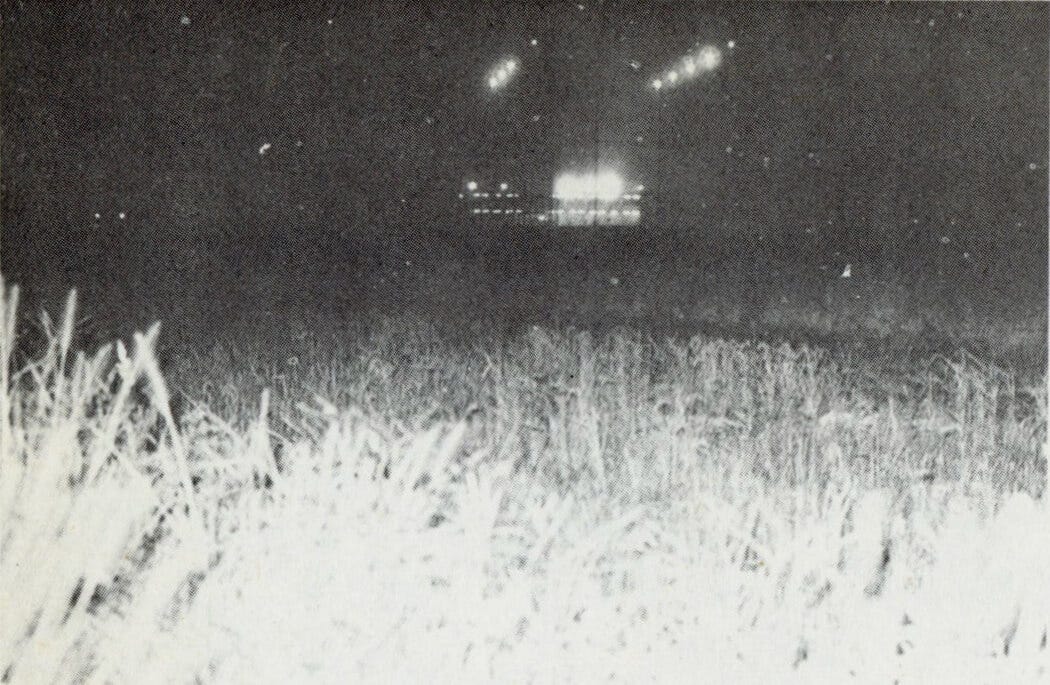 Nighttime view of the fields in Kera. Tsutomu Seki described this image as “a field in Kera Village where a mysterious saucer was reportedly seen several times.” Powerful floodlights from a distant golf driving range are visible in the background.