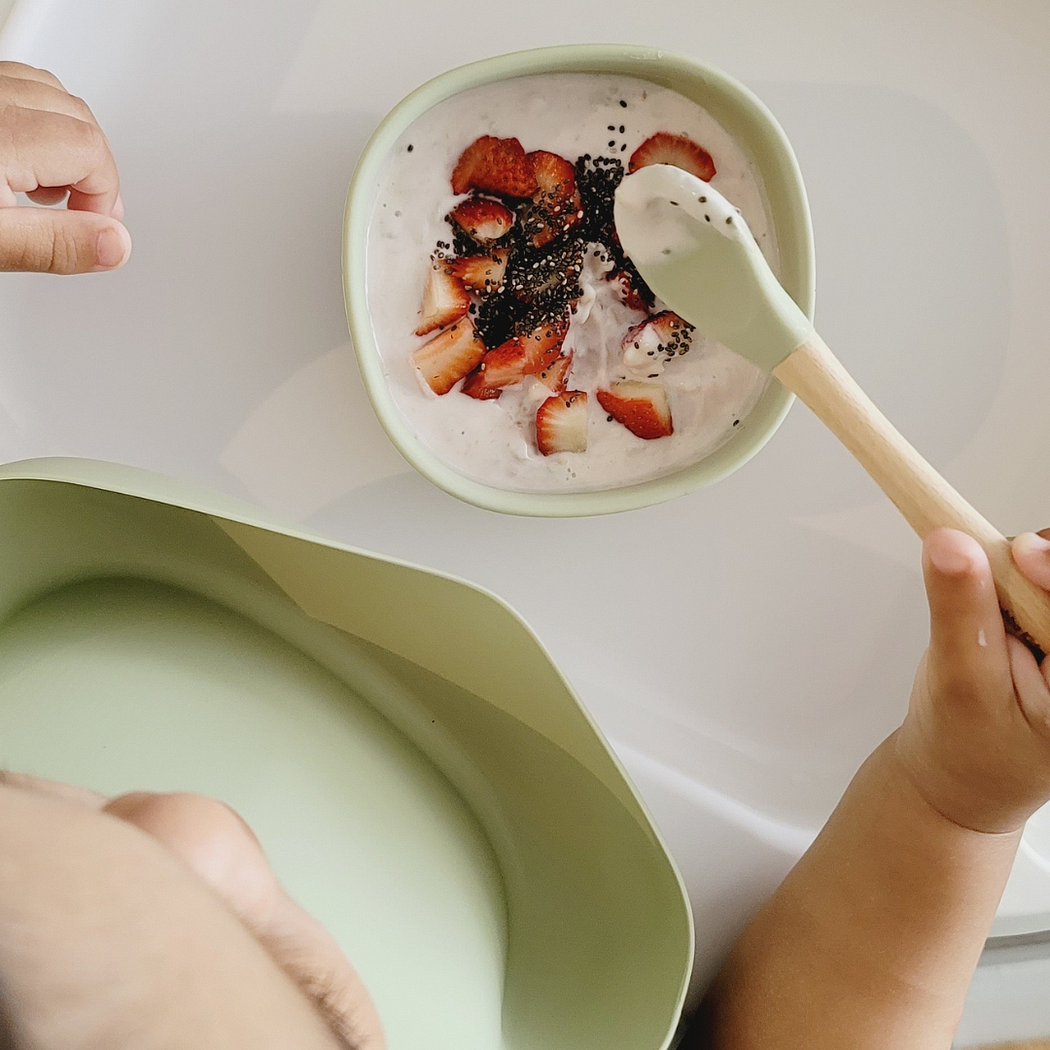 baby boy eating yougurt and sliced strawberries in a silicone suction bowl from Hunny Bubba Kids