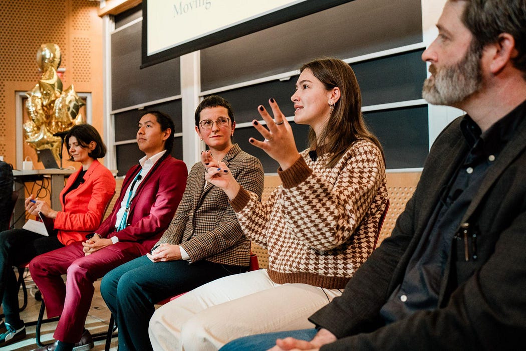 Five people seated in front of an auditorium.