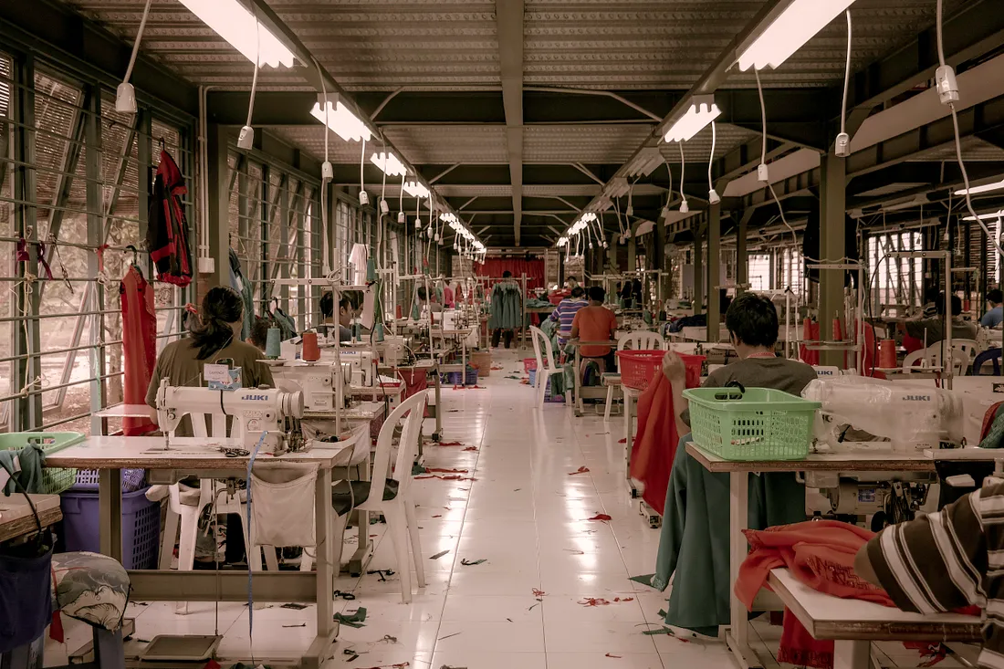 An image of people working in a textile factory, small work areas.