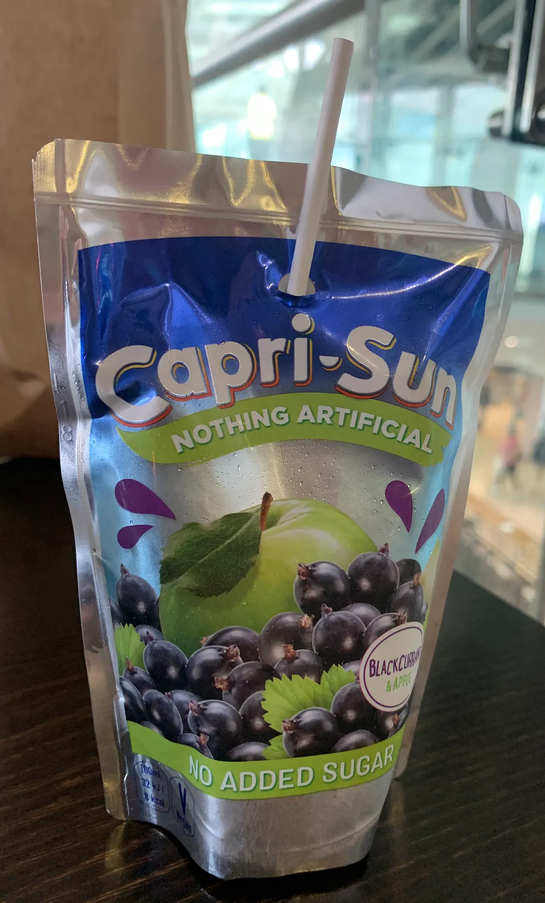 A capri-sun with a plastic straw sticking out of it.