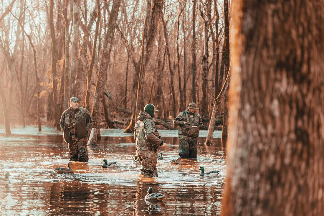 men hunting and fishing on a lake
