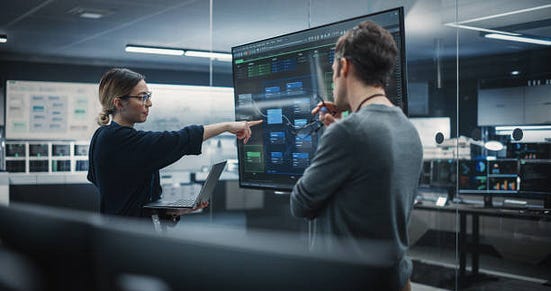 Two people analysing data on screen