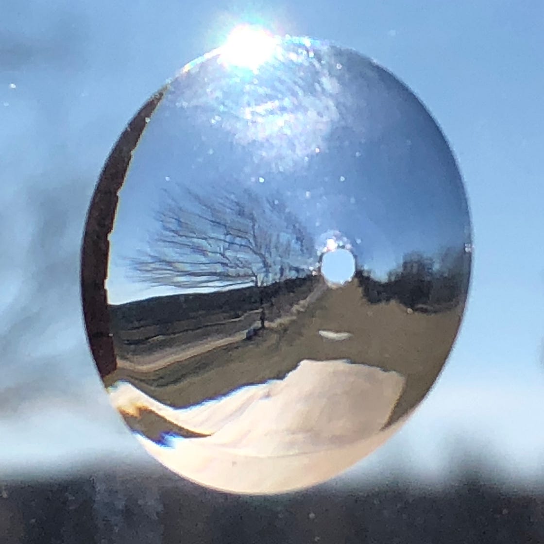 Bullet hole in a window in a rural setting.