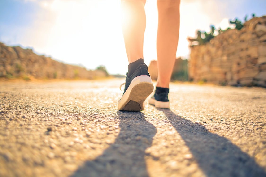 Woman Walking on Pathway Under The Sun. What happens when you walk more than 20k steps per day