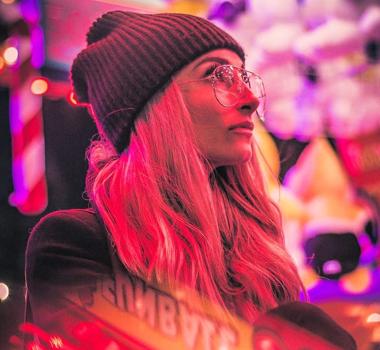 A young woman in a sea of neon lights.