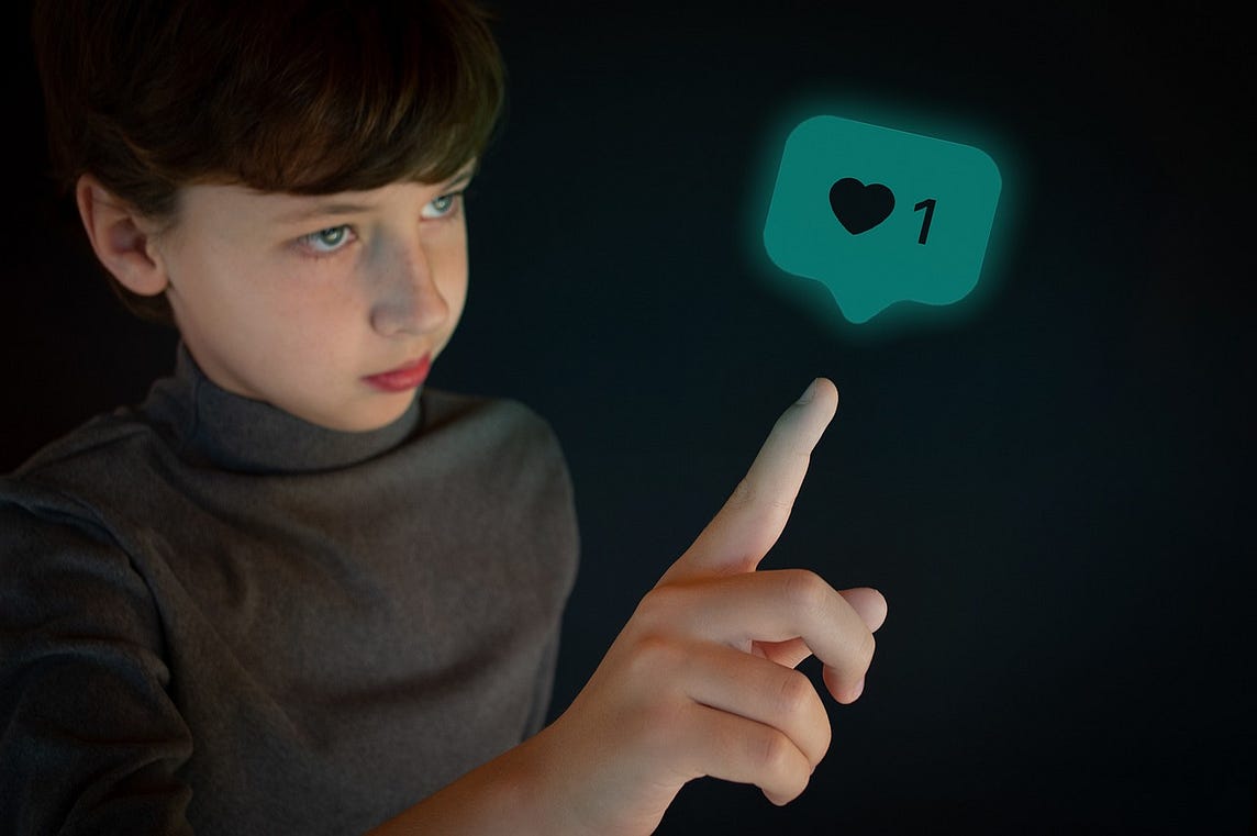IMAGE: A kid on a black background pointing to a bubble with a social media like