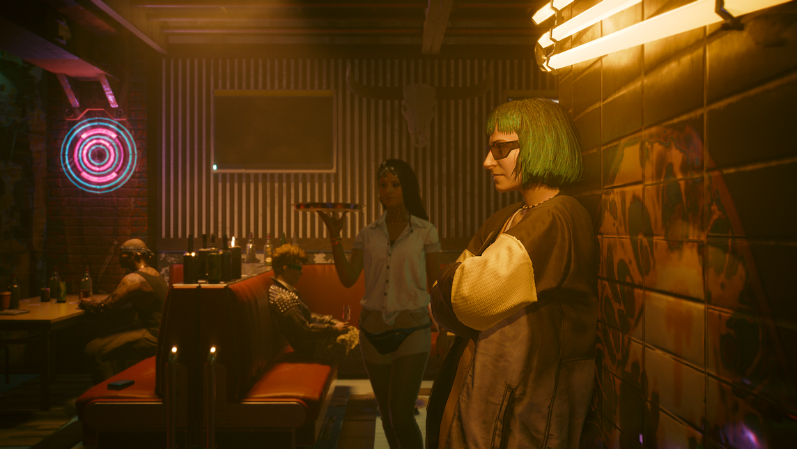 Some bar patrons and a waitress hang out near a yellow neon light in Cyberpunk on the Xbox Series S.