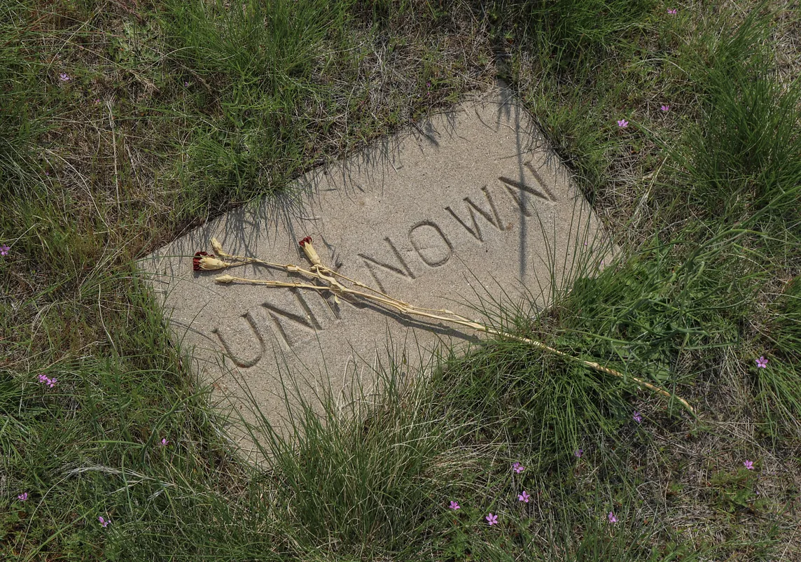 Photo of a gravestone with the name “unknown” carved into it