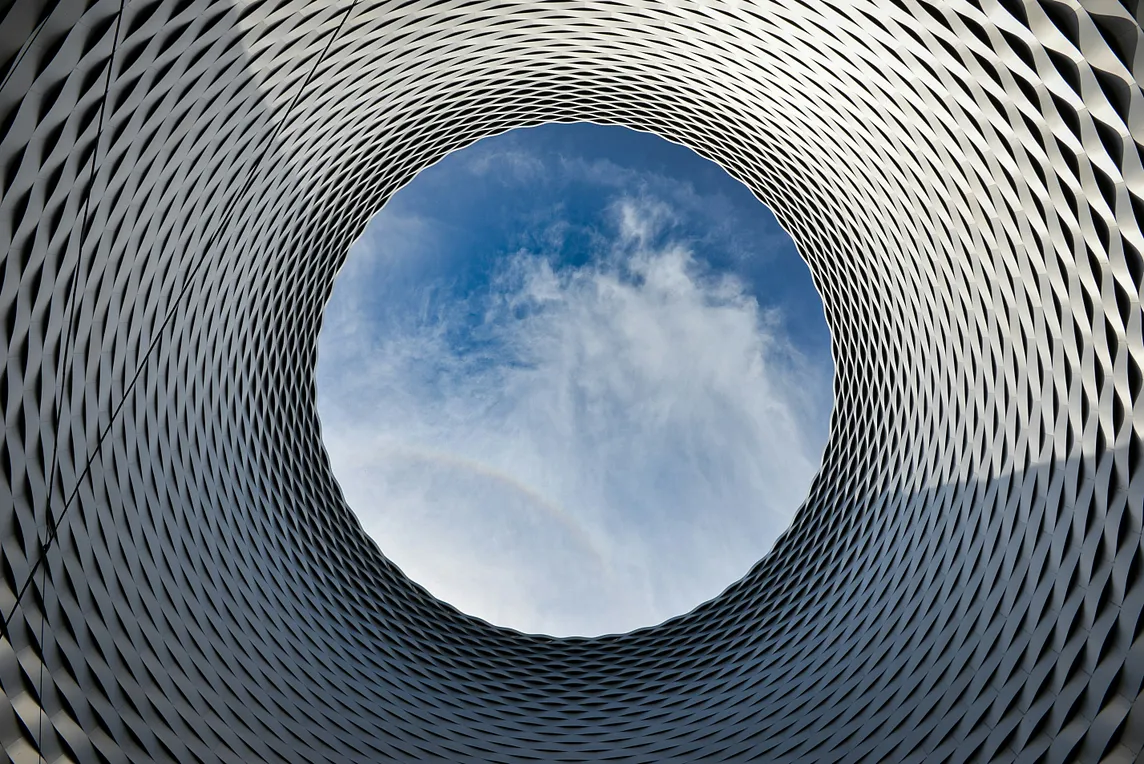 Picture of a view of the sky through a cylindrical, tessellated object