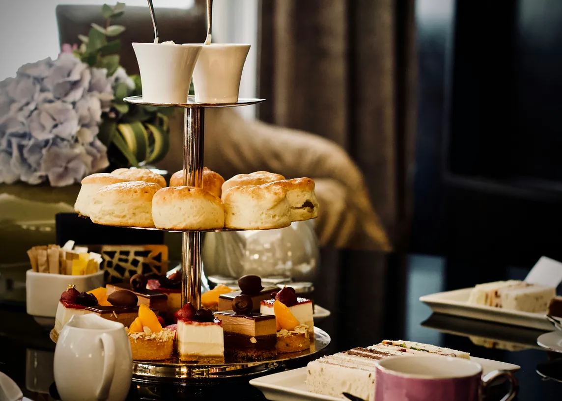 A tea service with scones and desserts on a three-tiered stand.