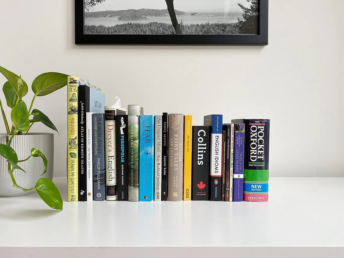 A small collection of books lined up on a desk