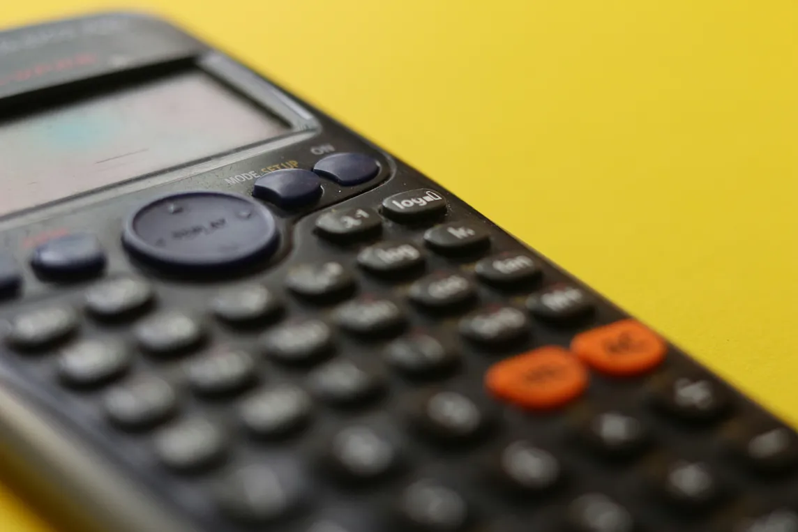 A near-threatening closeup of a calculator, buttons blurred.