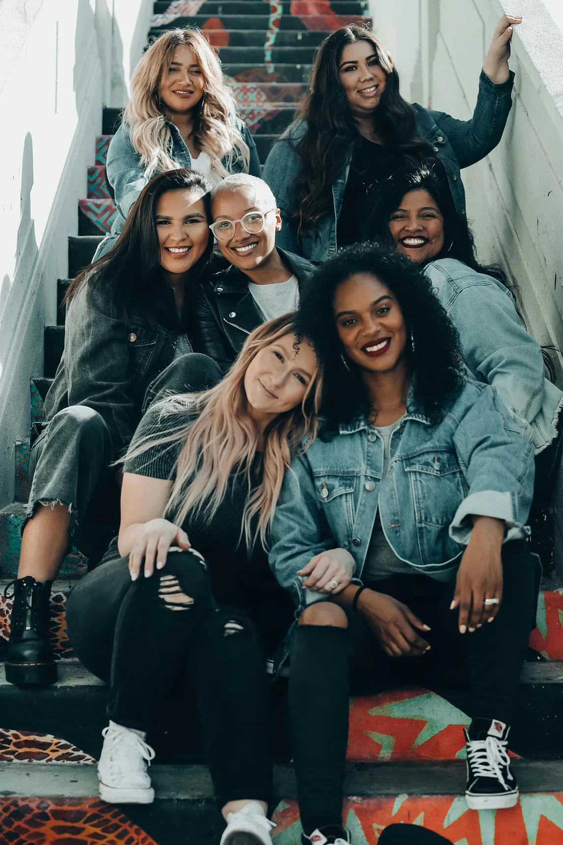 Photo of a group of women sitting on a staircase via Alt text on Medium