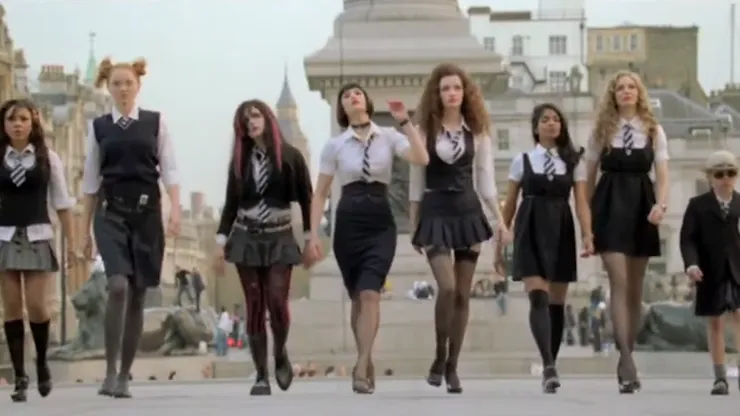 The girls of St. Trinian’s in their school uniform march down a street in London side-by-side, like heroes walking into battle.