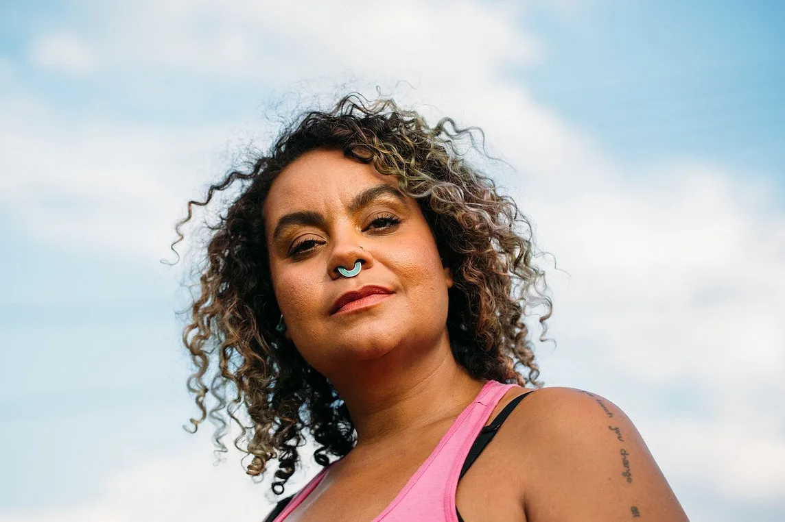 A closeup photo of adrienne maree brown against the sky.