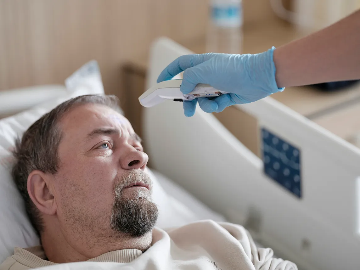 A man lying on the hospital bed.