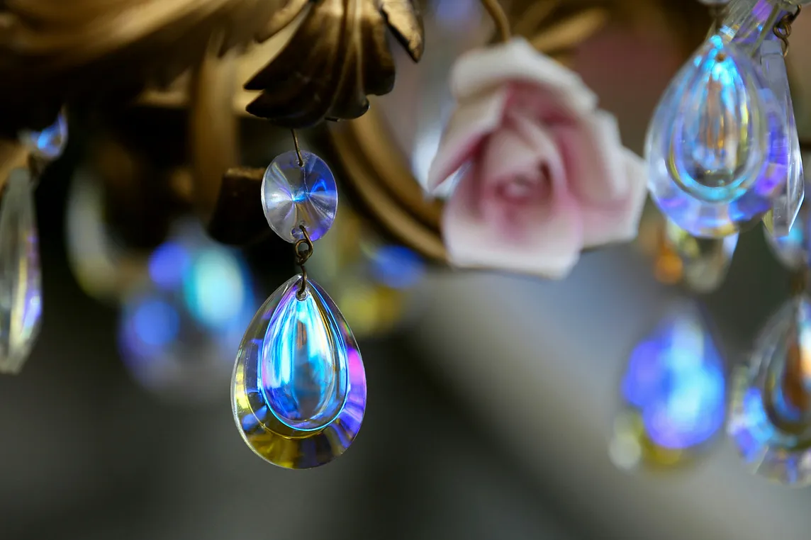 a shiny teardrop image on a background of pink roses and golden leaves