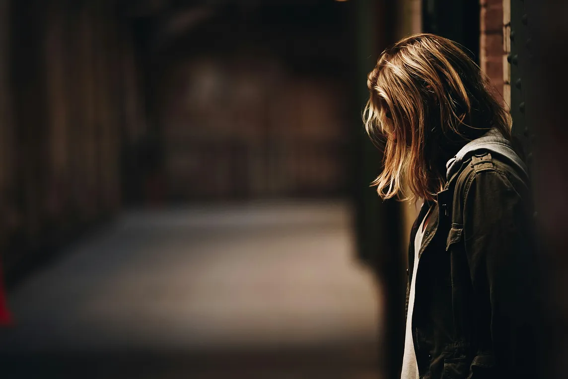 Photograph of an adolescent girl with her head down in the school hallway. She represents Miriam in this story — a girl with struggles