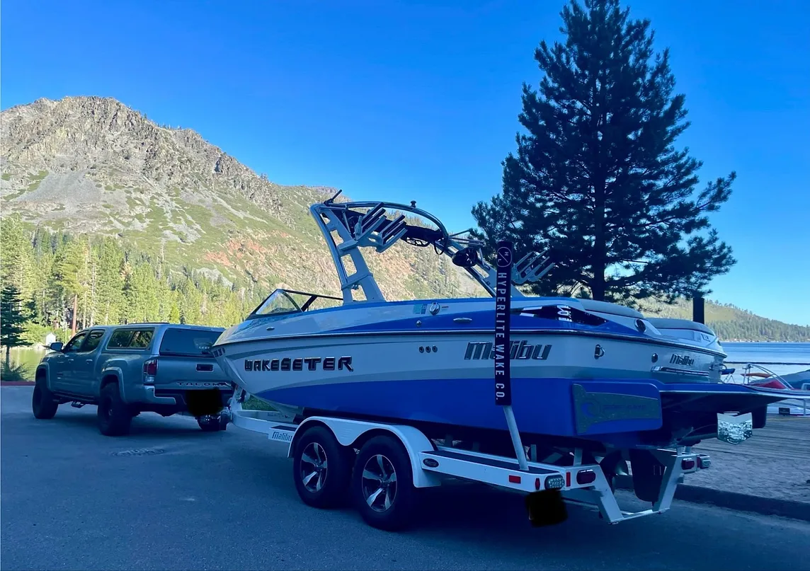 A photo taken by the author at Fallen Leaf Lake, CA. It is of our 2022 Toyota Tacoma and our 2014 Malibu Wakesetter. A dream both my husband and I had for years.