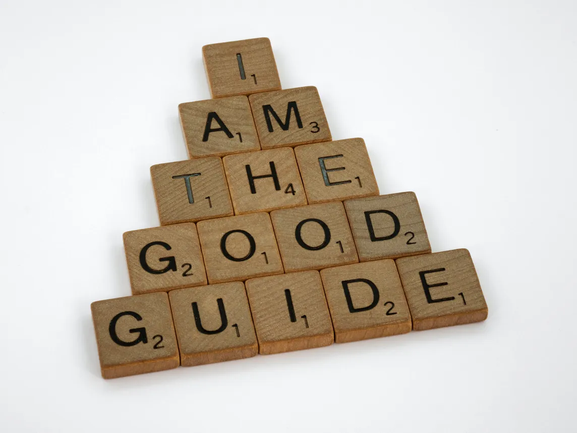 Square tiles with letters arranged to spell “I am the good guide.”