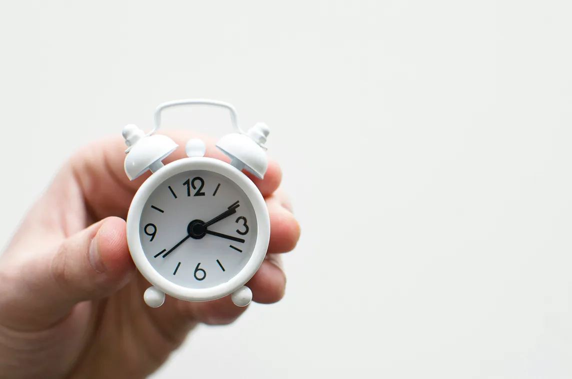 Hand holding alarm clock