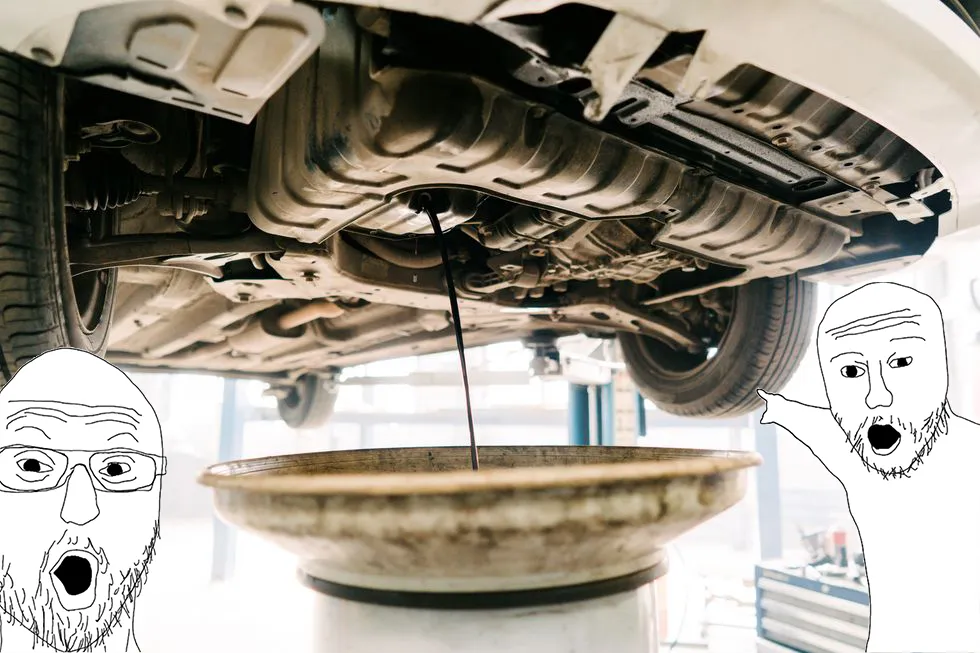 Two guys look in excitement at a car getting it’s oil changed