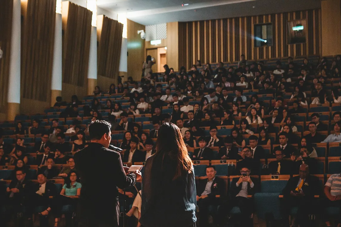 A man standing behind a podium in front of a large audience