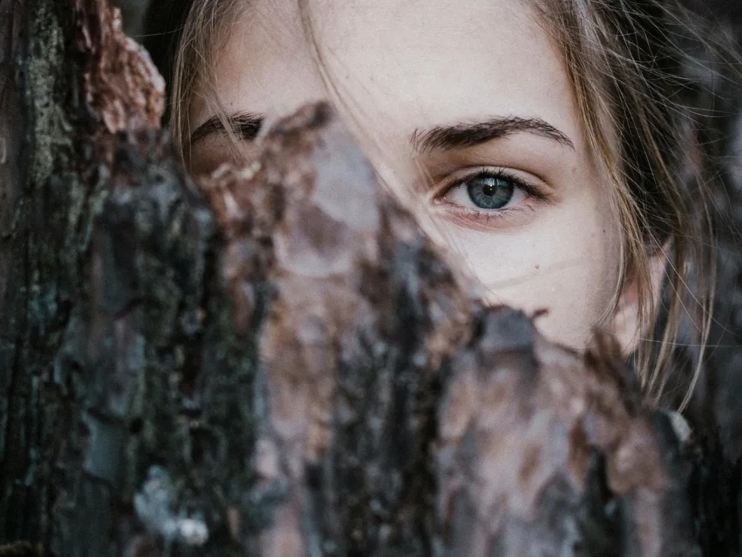 woman looking through leaves