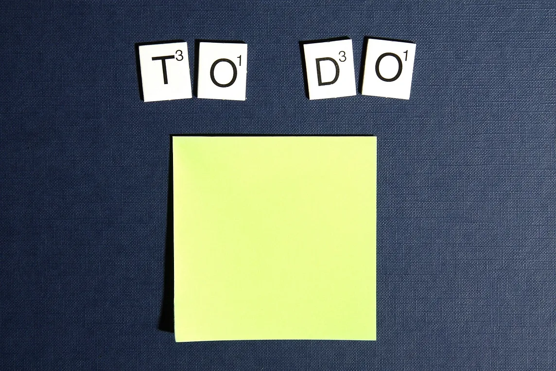 “To Do” written in Scrabble-like letters above a yellow, blank post-it note.