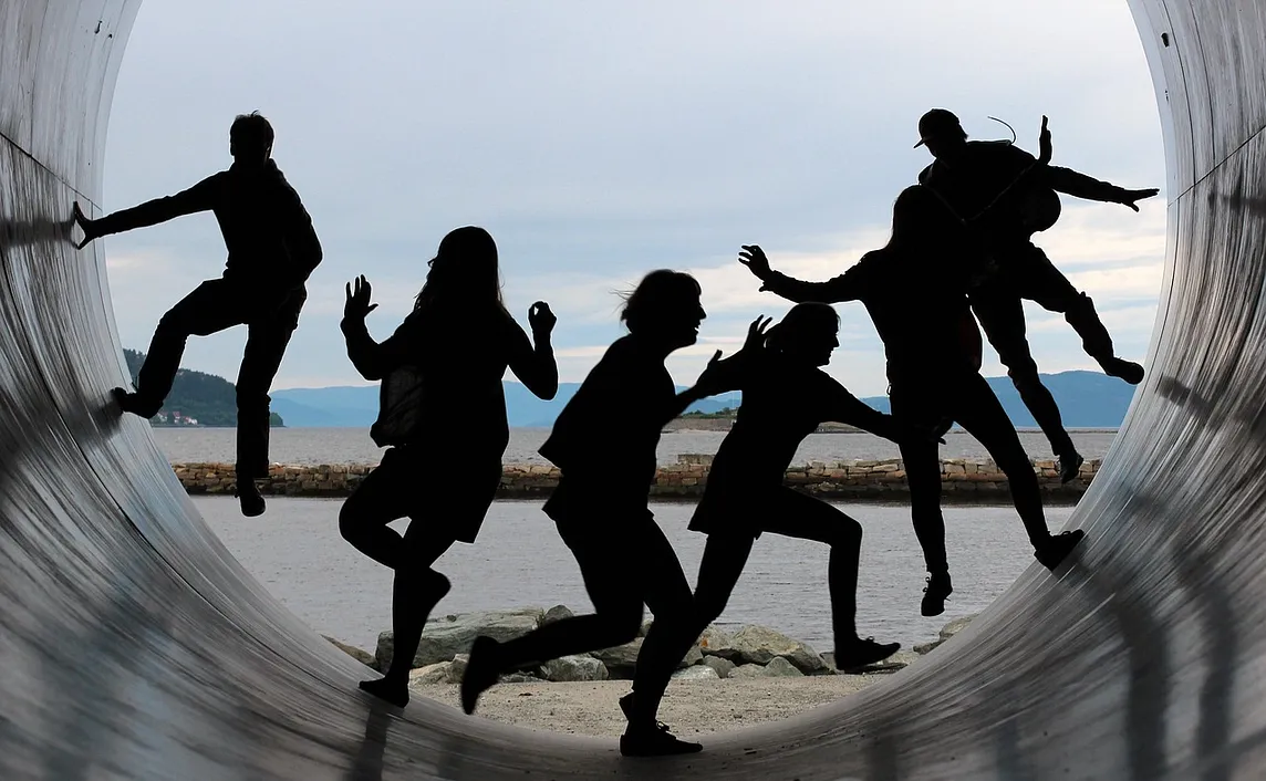 People silhouettes inside a large pipe