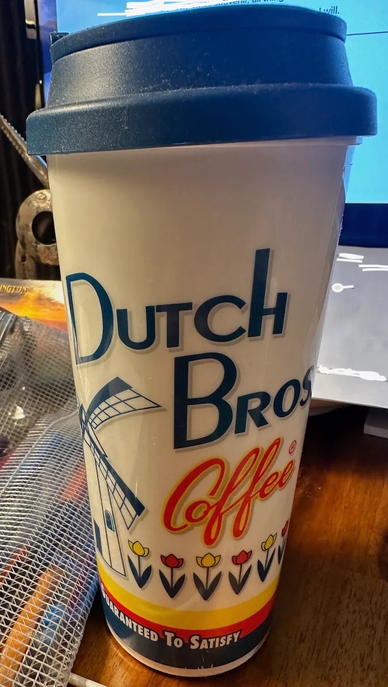 A Dutch Brothers travel coffee up with a windmill on it.