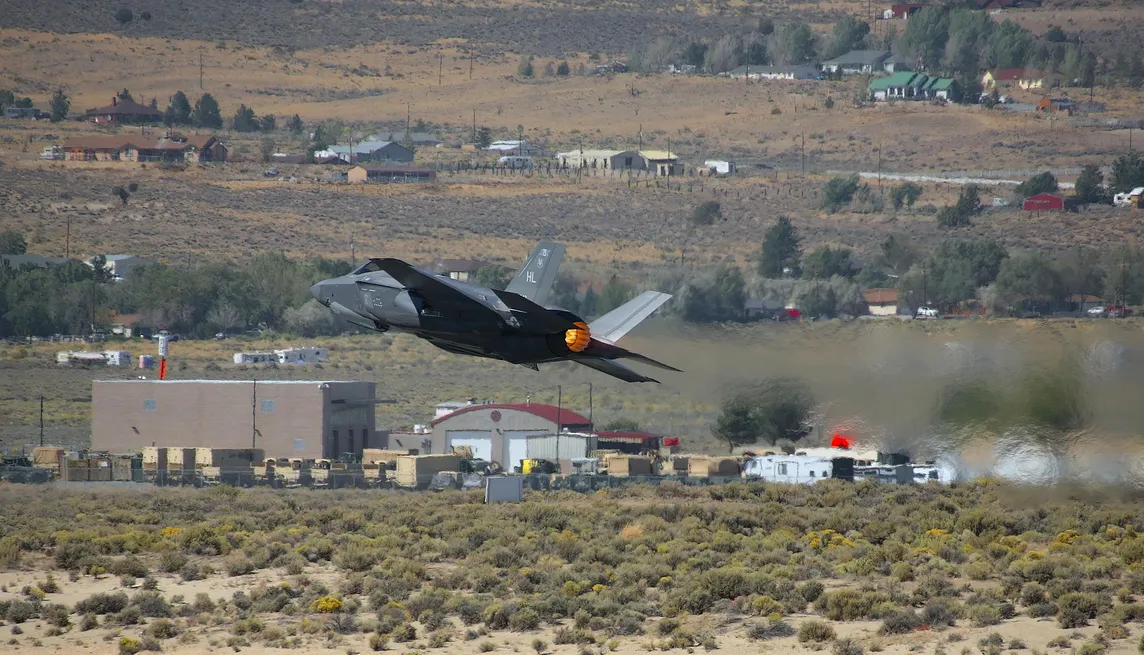 A fighter jet flying low to the ground.