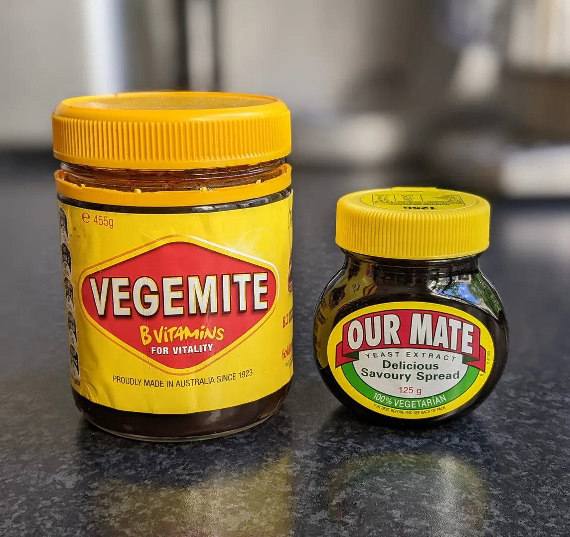 Jar of Vegemite on the left and a jar of Marmite (Our Mate in Australia) on the left.