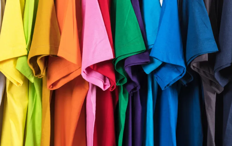 t-shirts hanging beautifully in a wardrobe in rainbow order