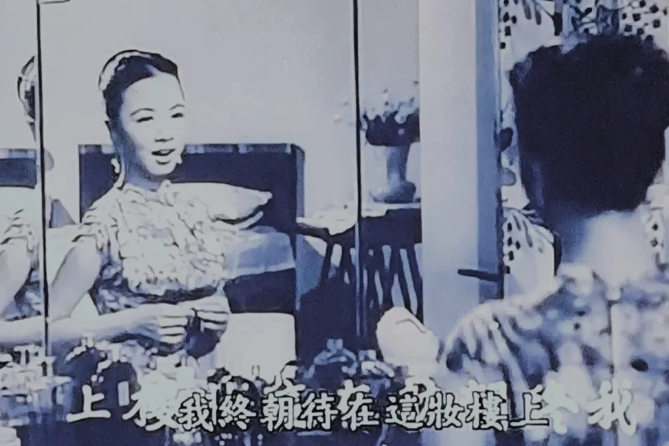 A photo snapped of a TV screen, showing a scene from an old black and white Chinese movie.