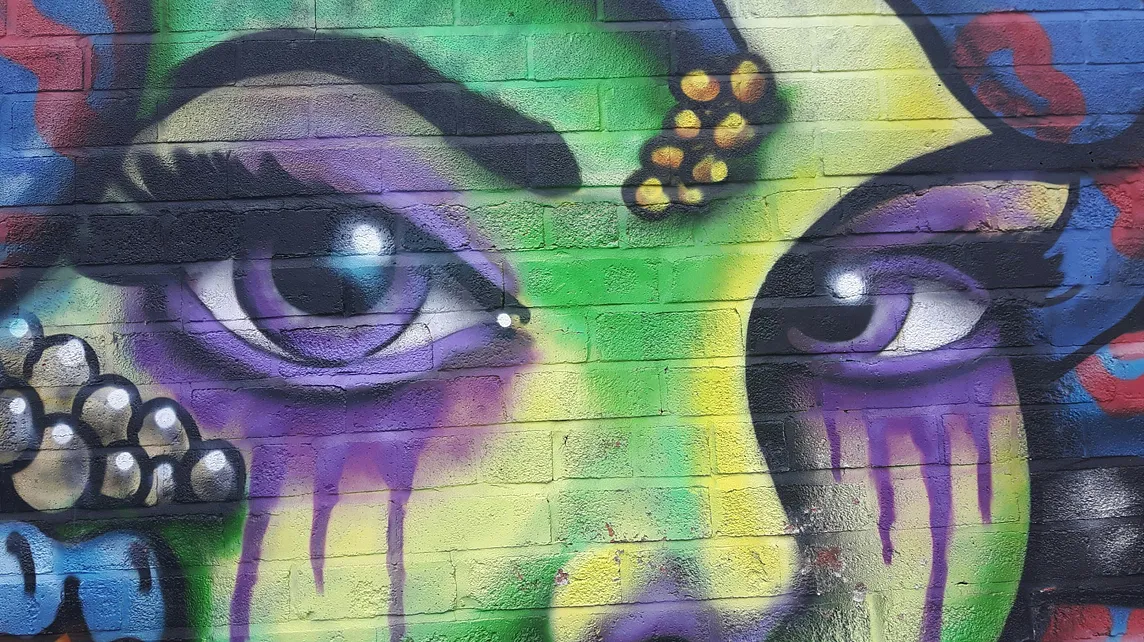 street art, a woman’s face with purple eyes