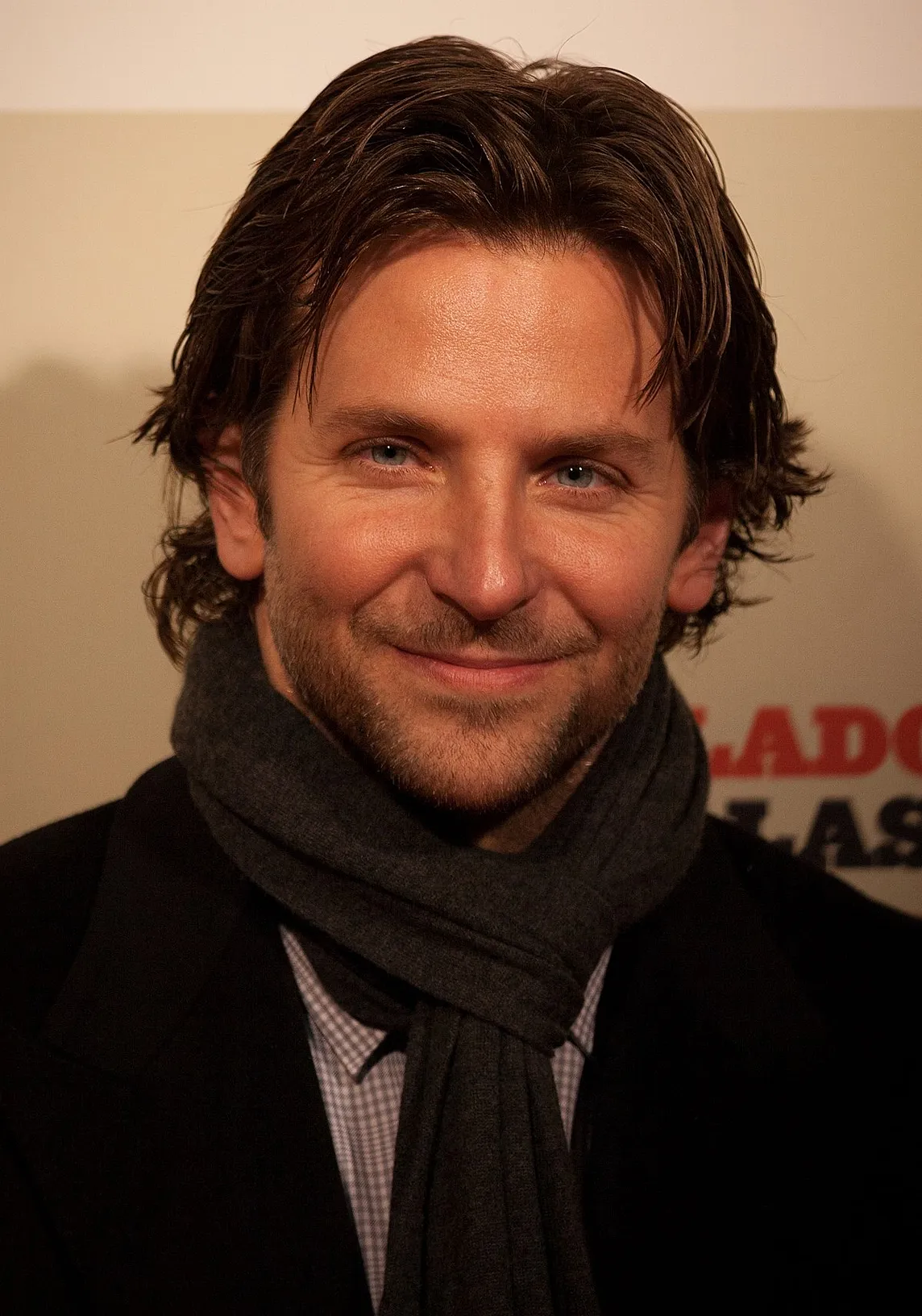 Bradley Cooper smiling to the camera wearing a black outfit