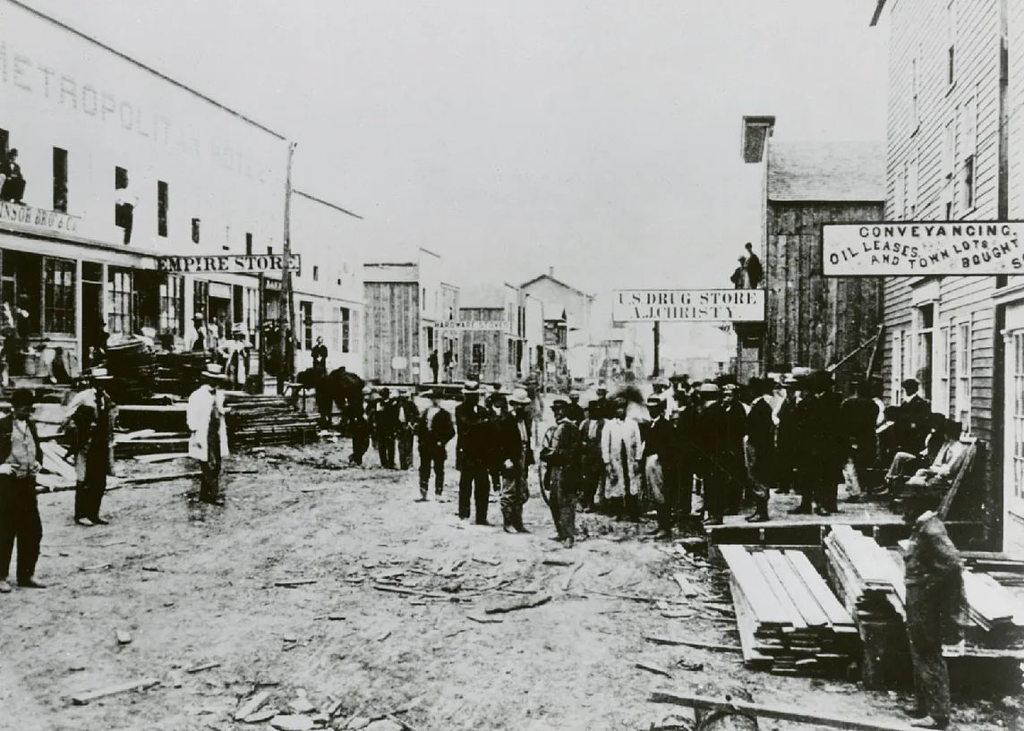 1865 photo of Holmden Street in Pithole, Pennsylvania, illustrating the bustling activity of the oil boomtown with storefronts, crowds, and businesses.