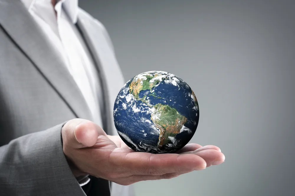 Man in a suit holding a globe