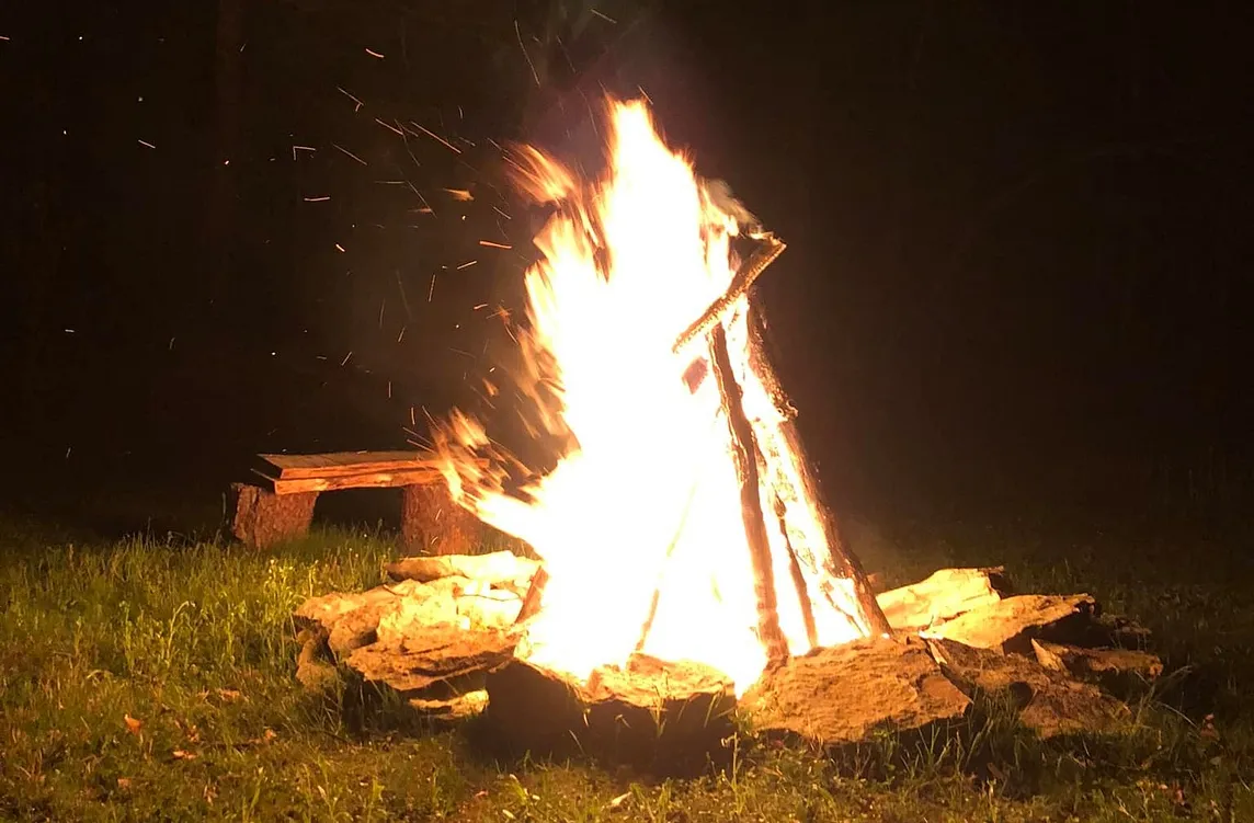 A tall campfire surrounded by stones