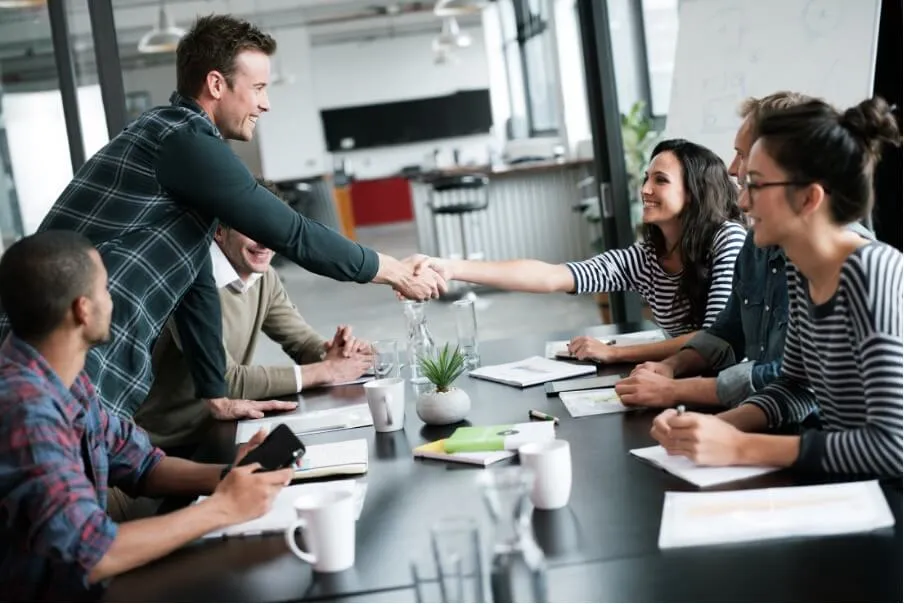 Employees onboarding a new employee with a New Hire Welcome Packet.