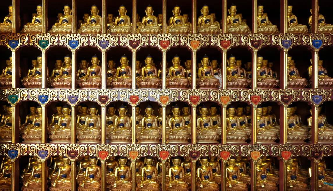 many small buddha statues on an altar