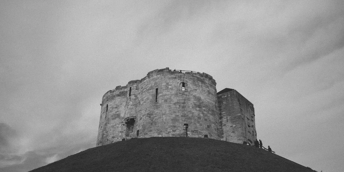 An old crumbling castle stands on a hill.