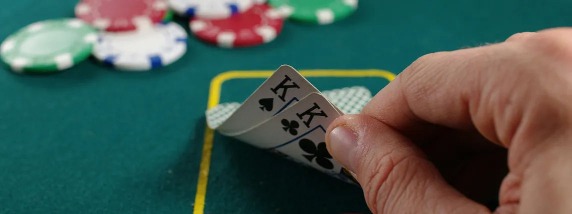 A poker player secretly looks at his cards.